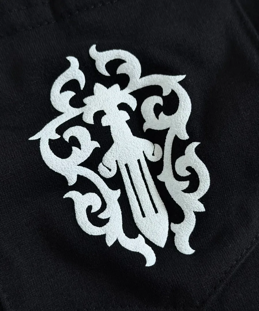 Деталь принта в виде кинжала на кармане черной футболки Chrome Hearts