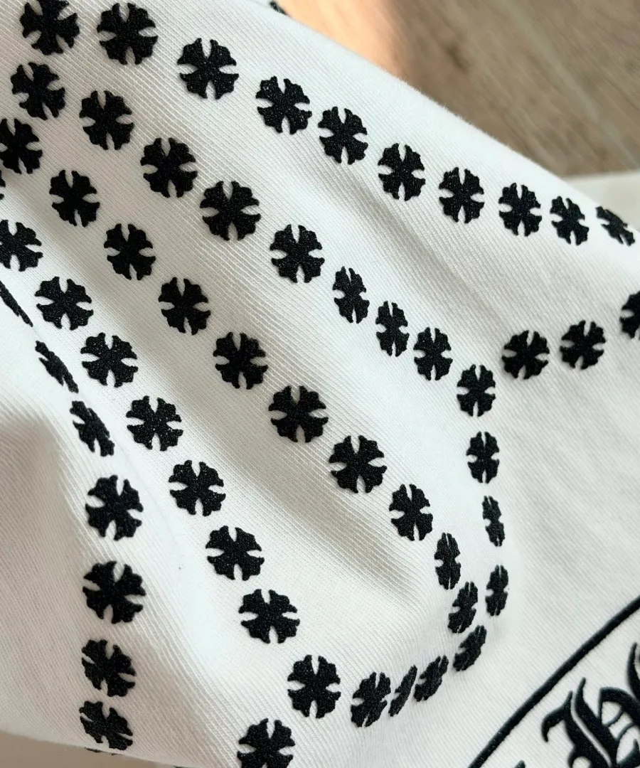 Крупный план принта в виде креста на белом лонгсливе Chrome Hearts