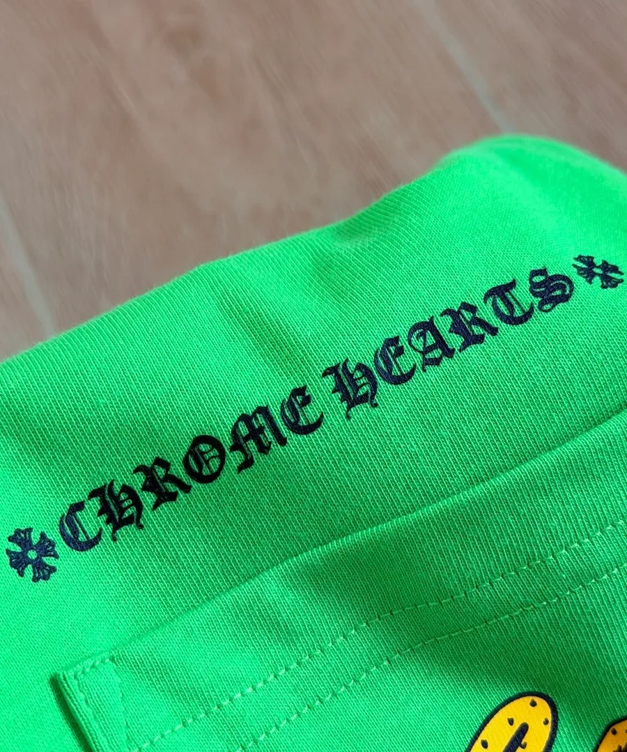 Принт Chrome Hearts над карманом зеленой футболки