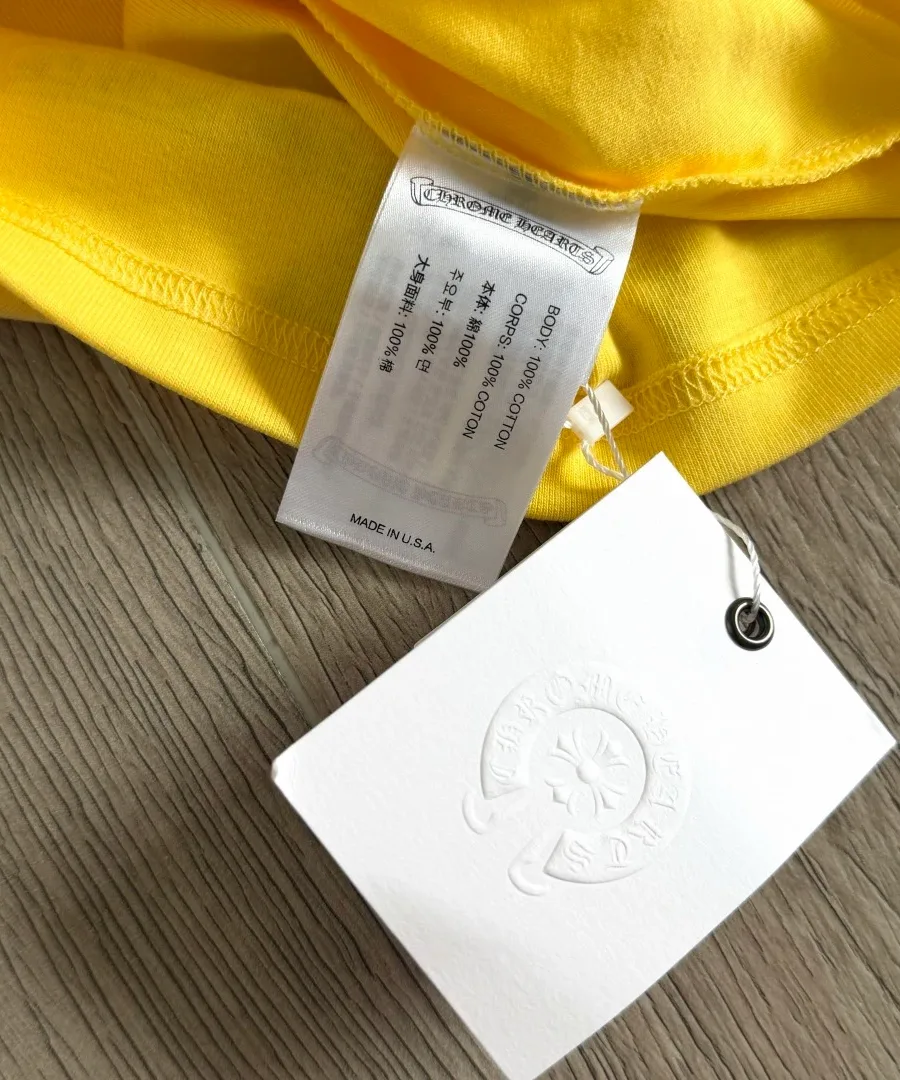Фирменная бирка с составом 100% хлопок на желтом топе Chrome Hearts