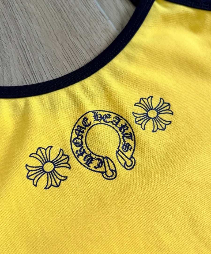 Крупный план принта с подковой на желтом топе Chrome Hearts