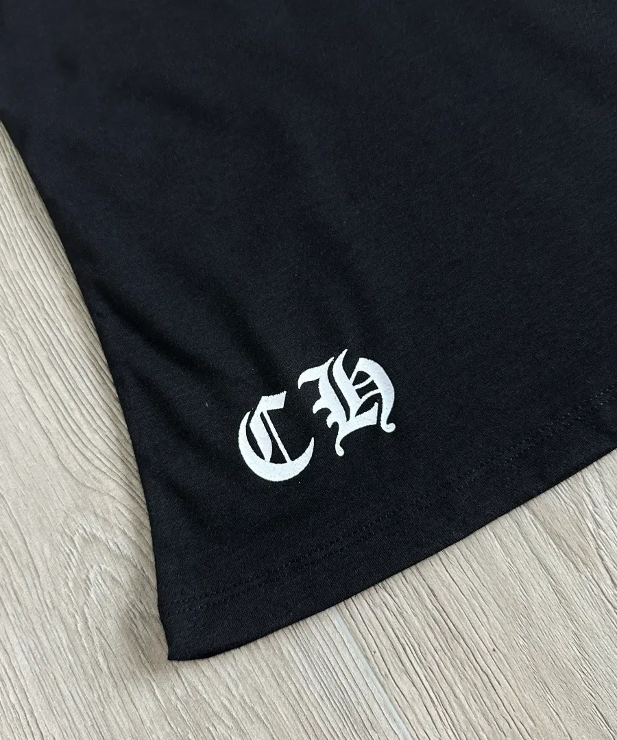 Деталь готического логотипа CH на подоле черной футболки Chrome Hearts