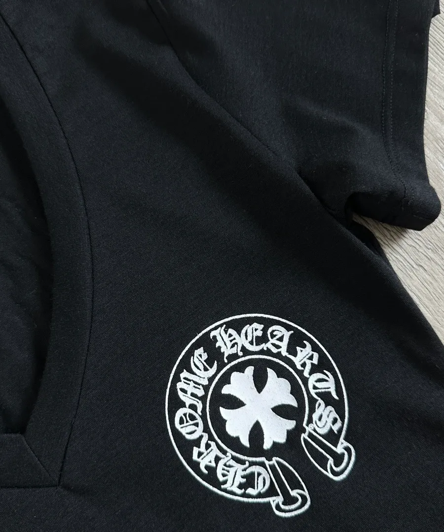 Принт в виде подковы и креста на груди черной футболки Chrome Hearts
