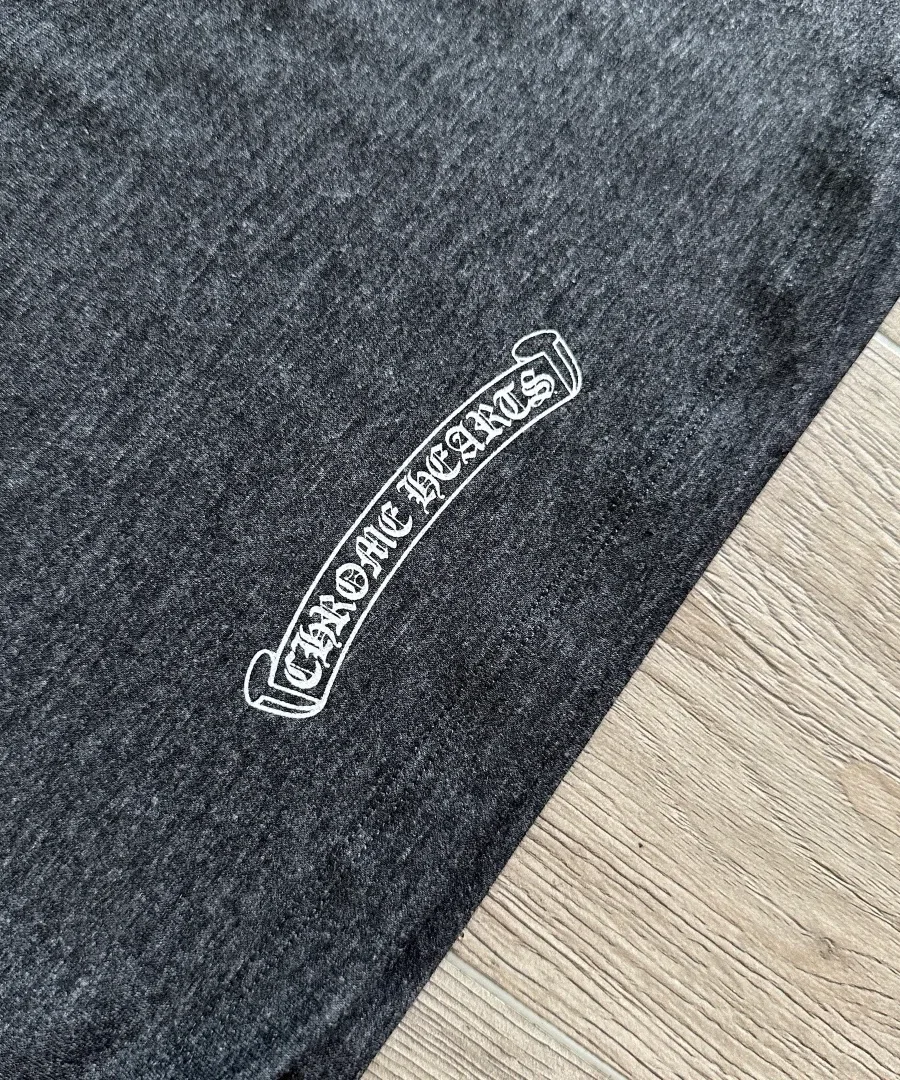 Деталь небольшого логотипа Chrome Hearts на серой футболке