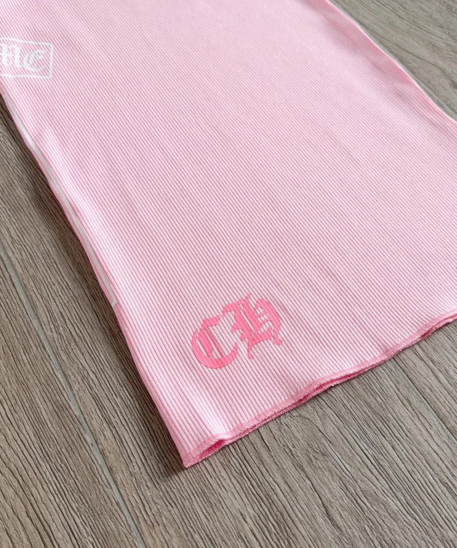 Деталь нижнего края с логотипом CH на розовом платье Chrome Hearts
