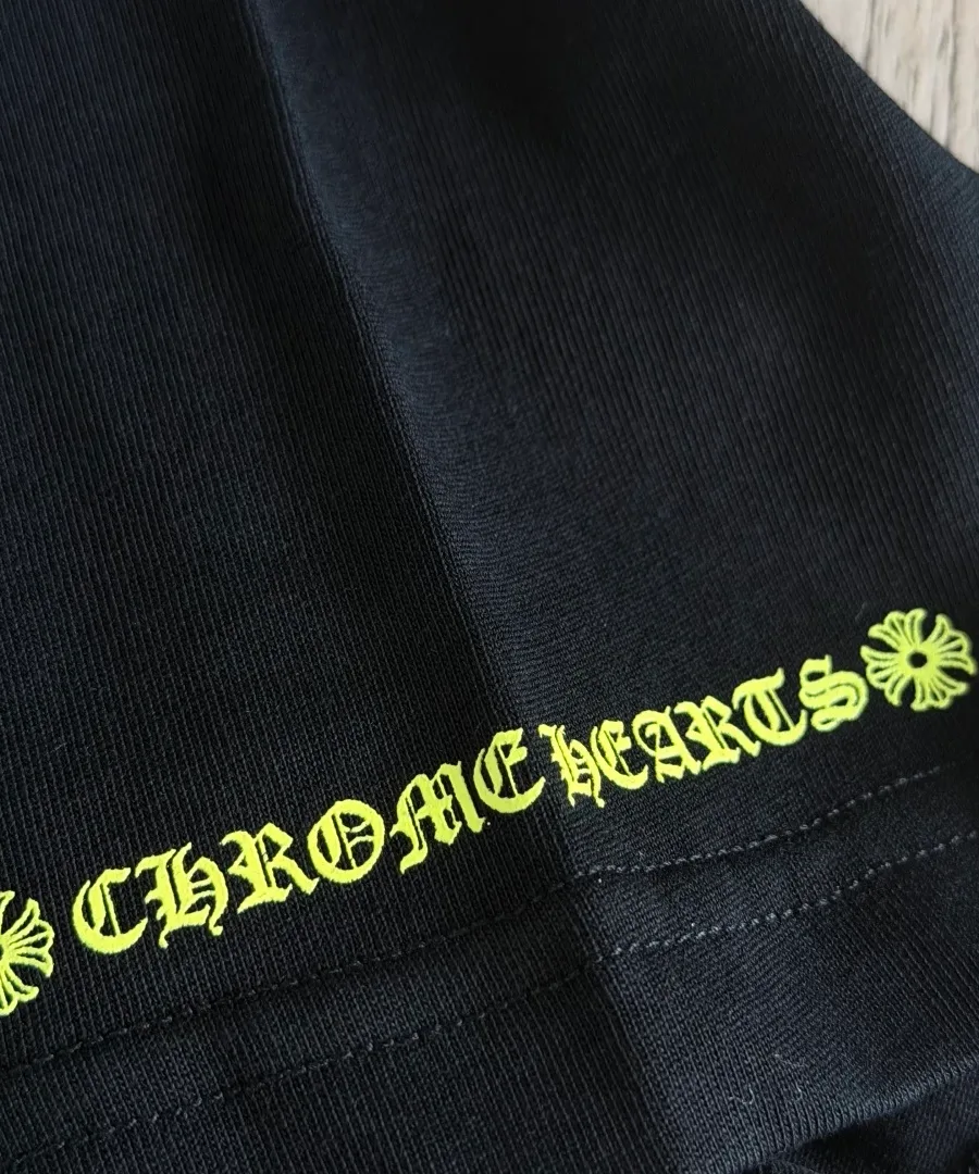 Неоново-зеленый принт с надписью на рукаве черной футболки Chrome Hearts