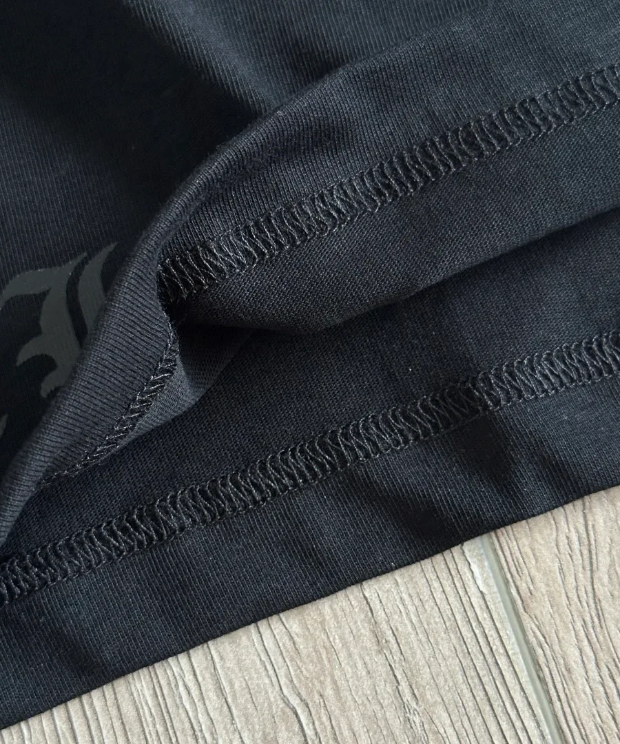 Крупный план нижнего шва черной футболки Chrome Hearts