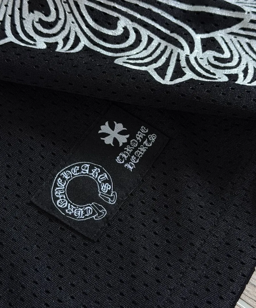 Крупный план нашивки с логотипом Chrome Hearts на черной сетчатой ткани