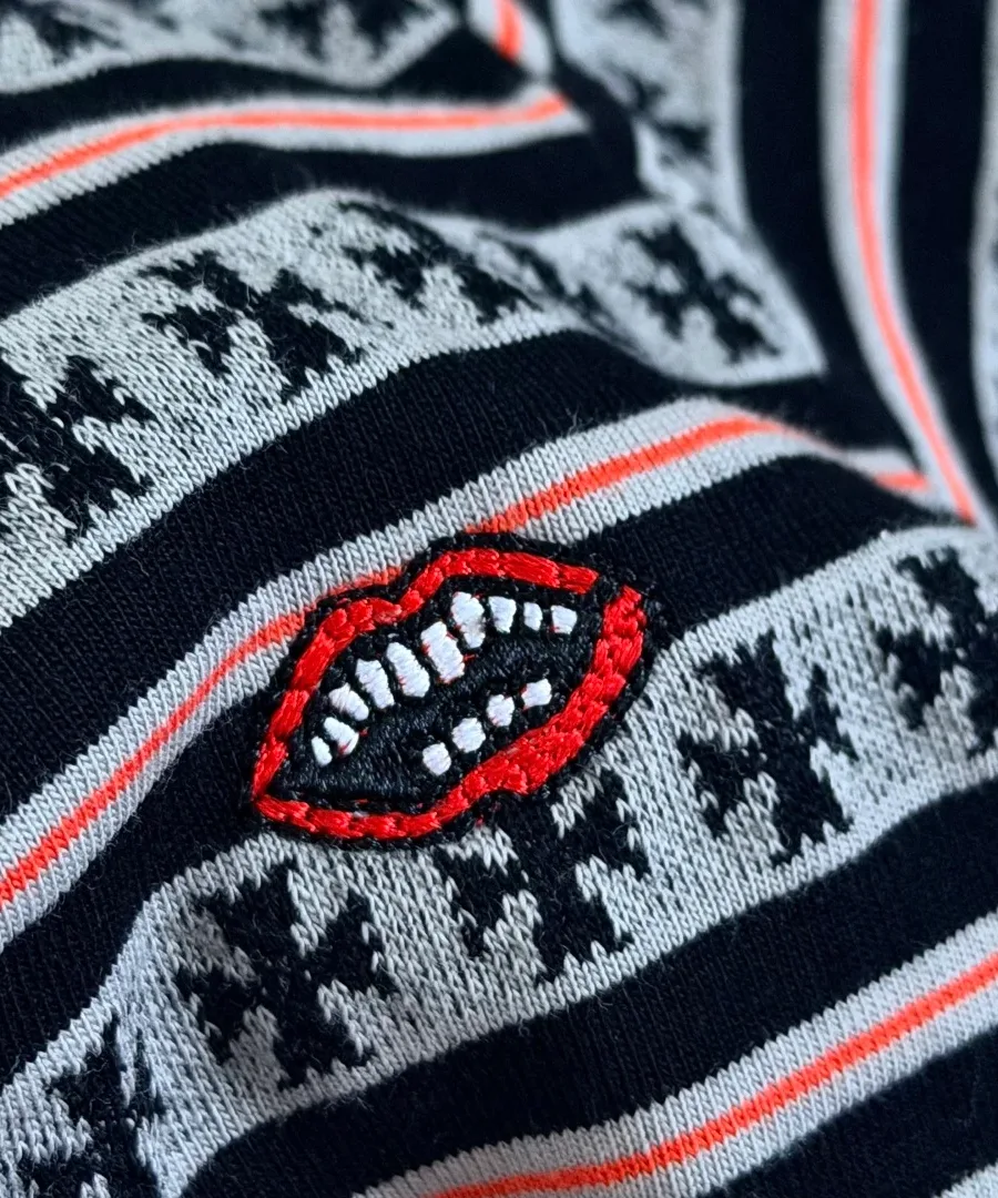 Крупный план вышивки в виде губ на футболке Chrome Hearts