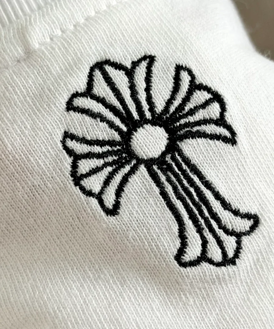 Деталь вышивки креста на белой футболке Chrome Hearts
