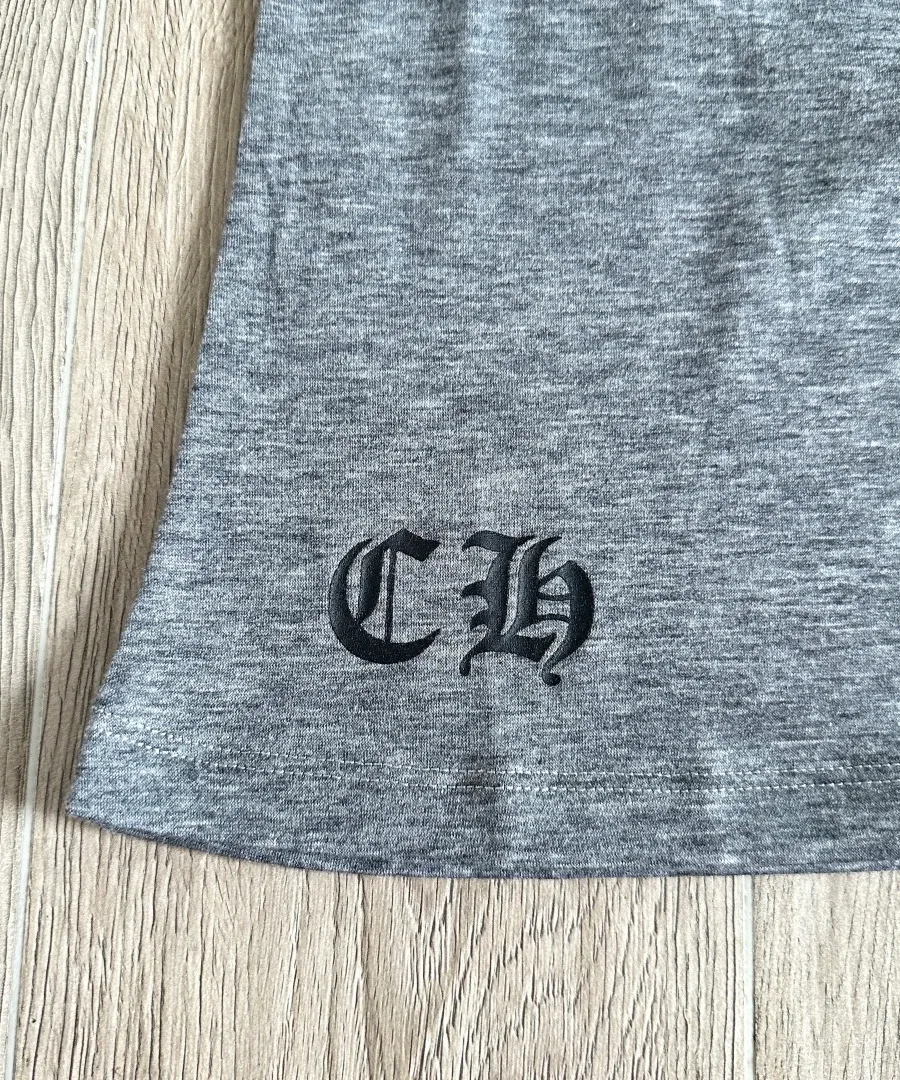Вышивка логотипа CH на подоле светло-серой футболки Chrome Hearts