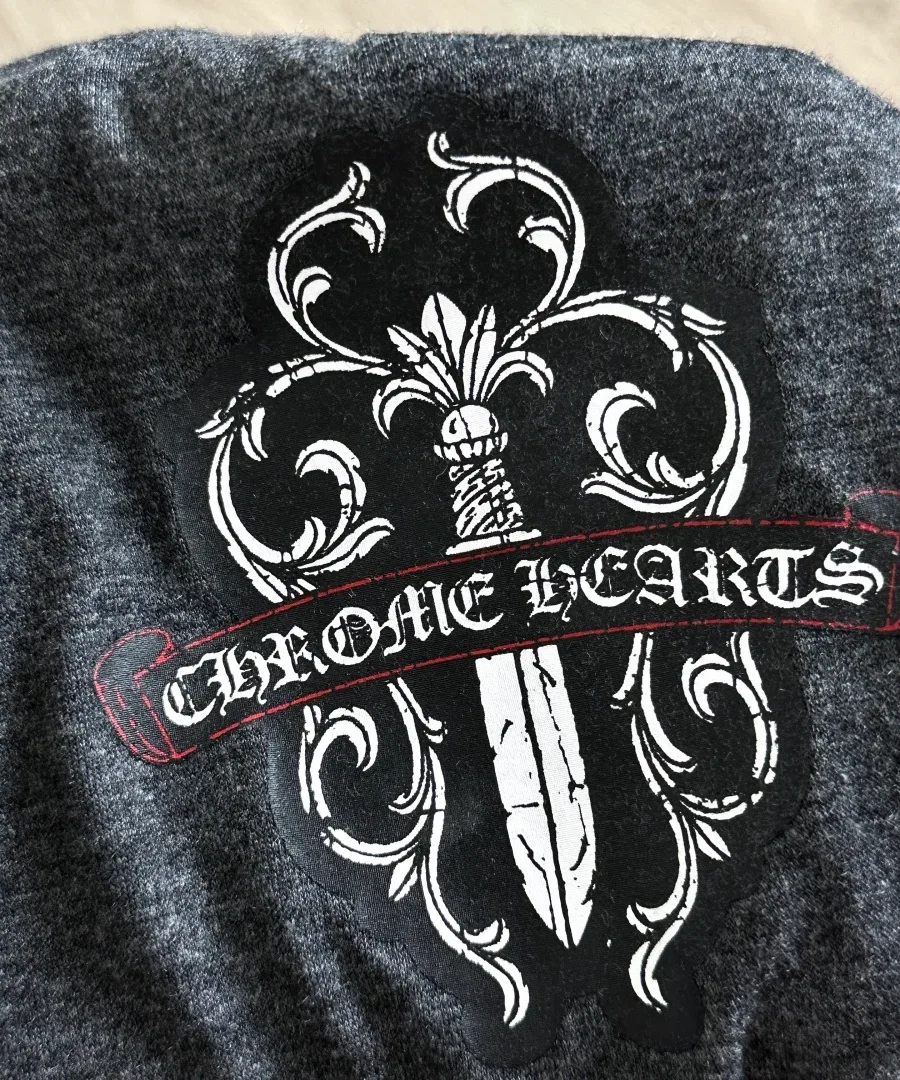 Деталь принта с логотипом на темно-серой футболке Chrome Hearts