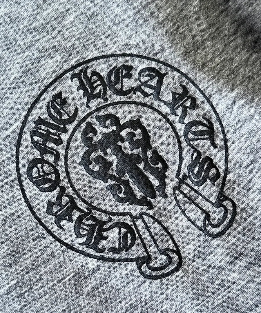 Круглый фирменный логотип на груди серой футболки Chrome Hearts