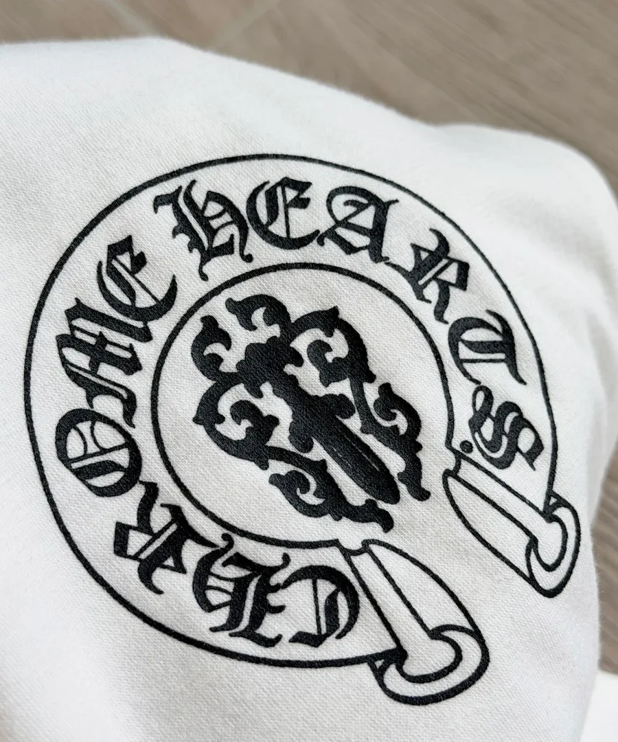 Круглый фирменный логотип на груди белой футболки Chrome Hearts