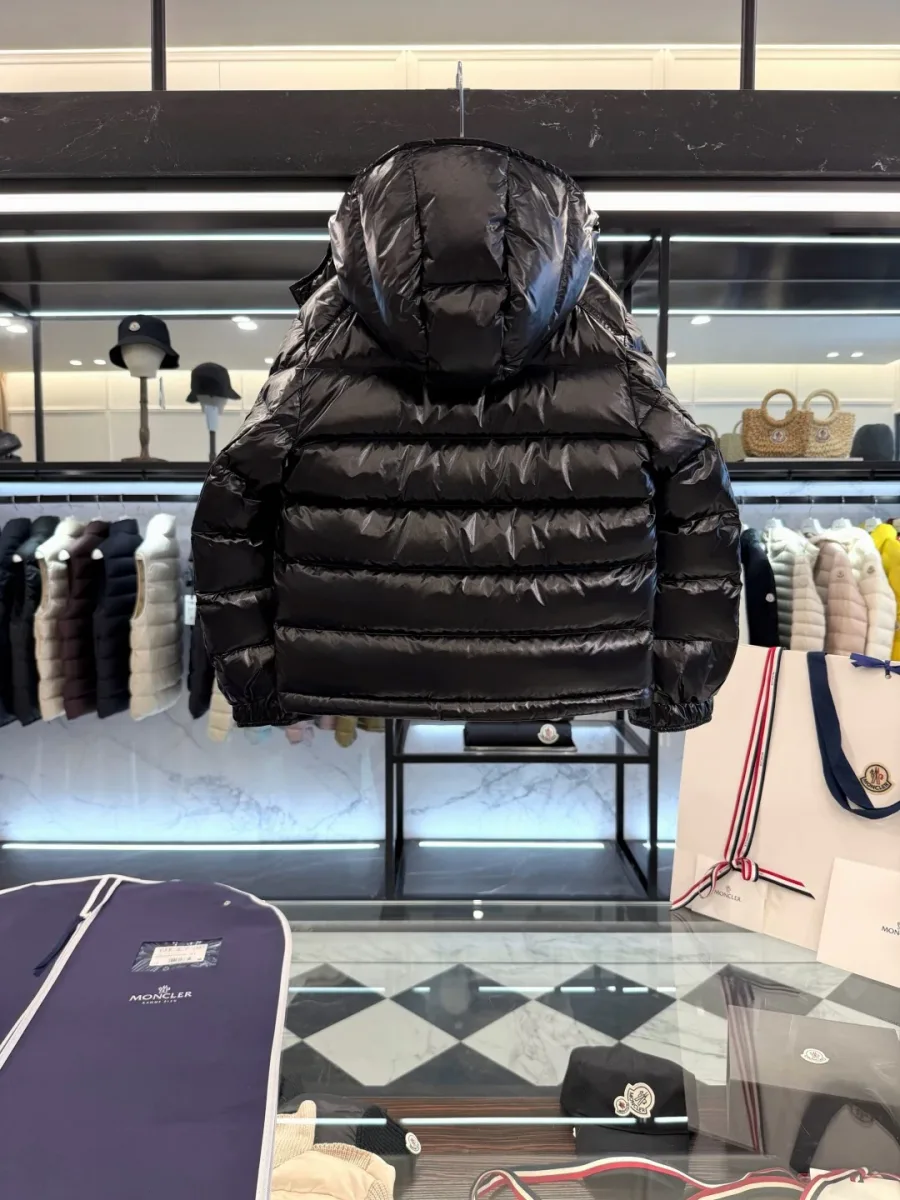 Чёрный пуховик Moncler с капюшоном, вид под углом с демонстрацией манжеты на кнопке