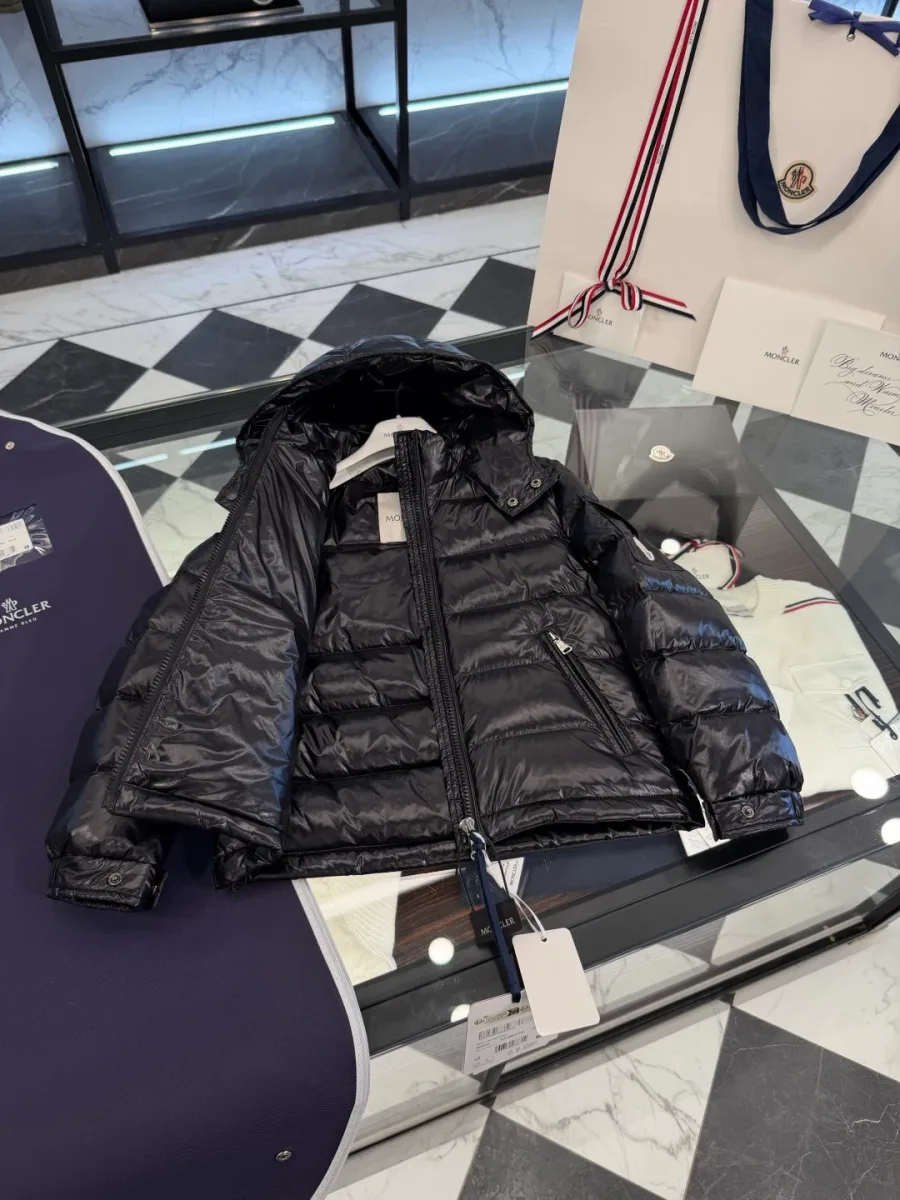Подкладка чёрного пуховика Moncler с текстильной нашивкой-комиксом, крупный план
