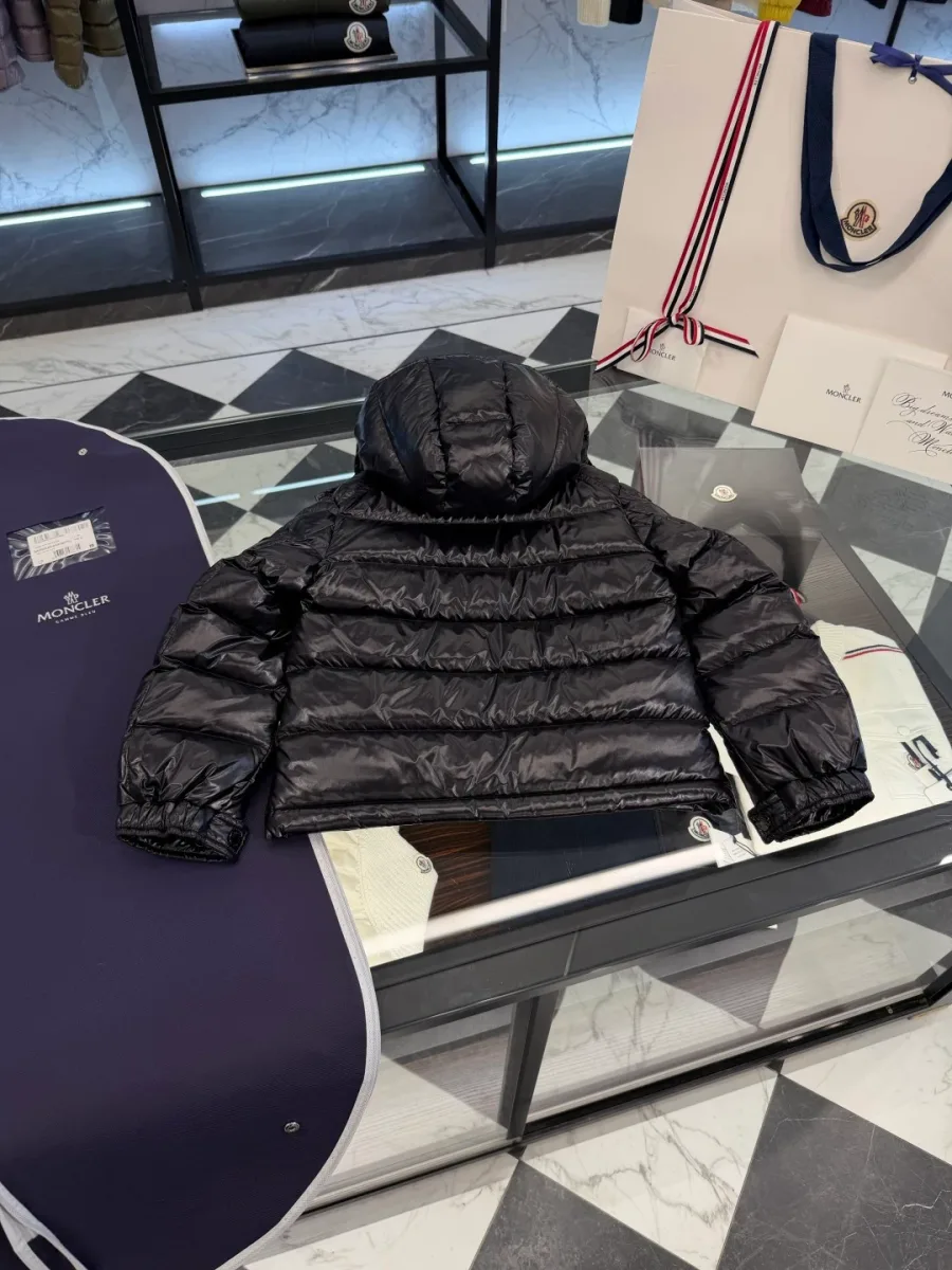 Чёрный пуховик Moncler с расстёгнутым воротом на плечиках