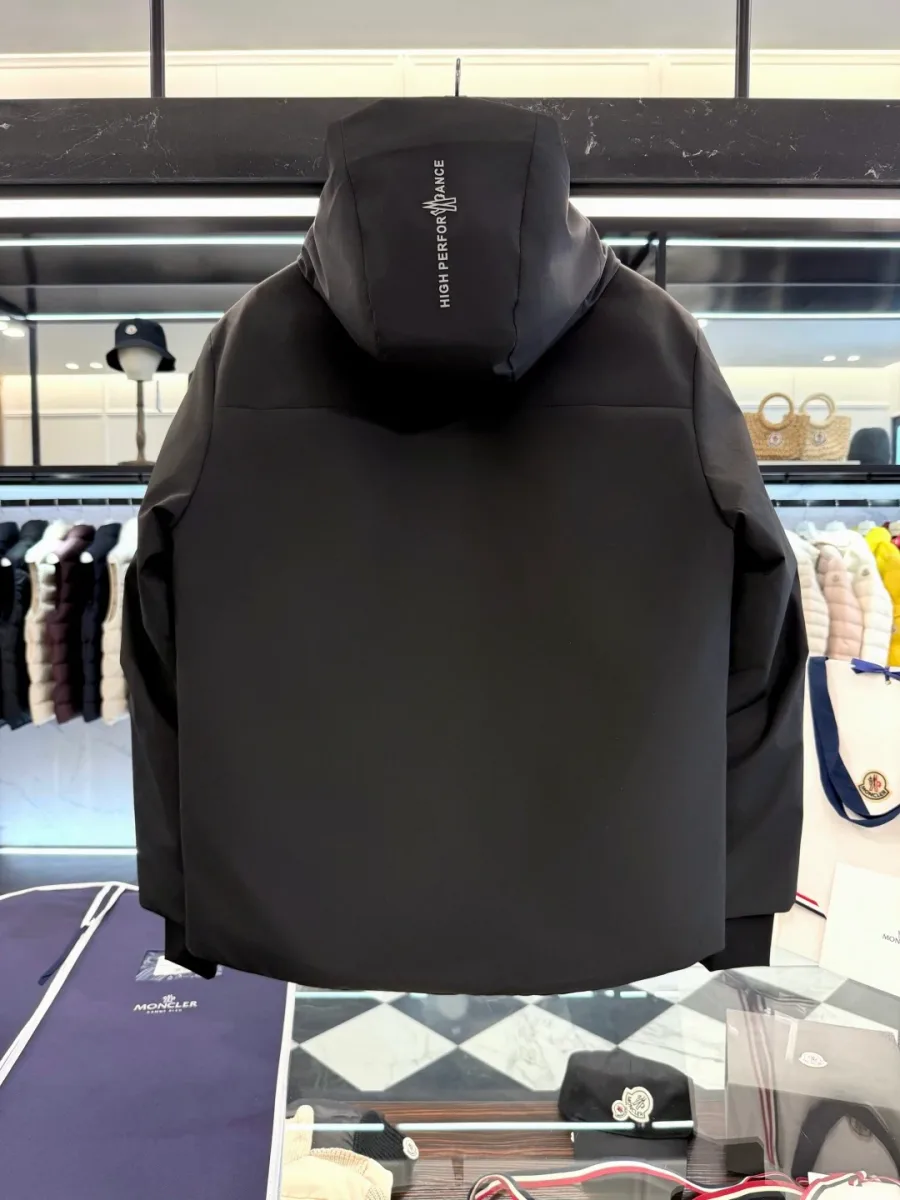 Вид со спины на чёрный пуховик Moncler Grenoble с гладкой матовой спинкой и принтом на капюшоне