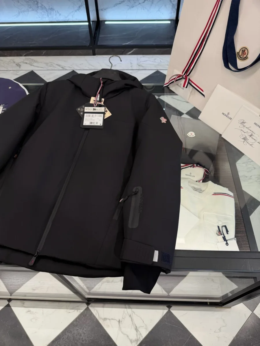Левый рукав чёрного пуховика Moncler Grenoble с прорезным карманом на молнии и эластичной манжетой