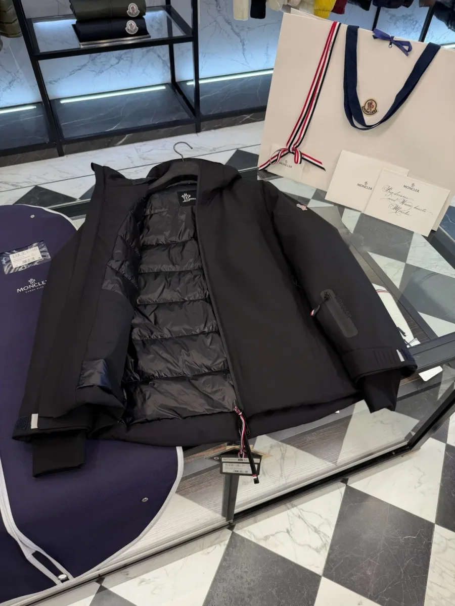 Внутренняя часть раскрытого чёрного пуховика Moncler Grenoble с горизонтальной стёжкой пуховых камер