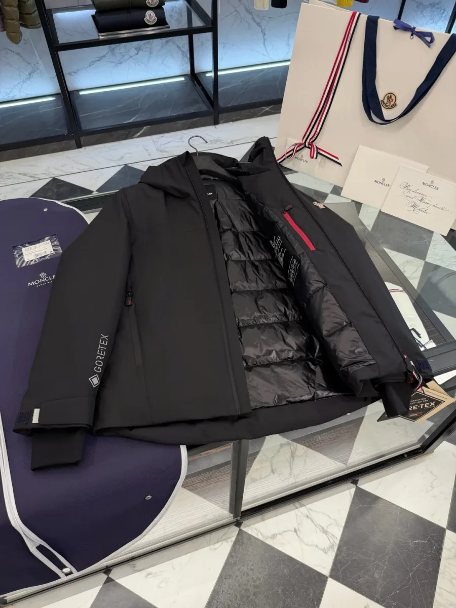 Раскрытый чёрный пуховик Moncler Grenoble с внутренним карманом на молнии с красной рамкой слева