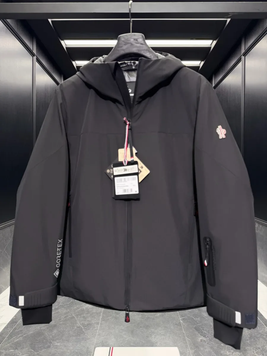 Фронтальный вид чёрного пуховика Moncler Grenoble с карманом для ски-пасса на левом предплечье
