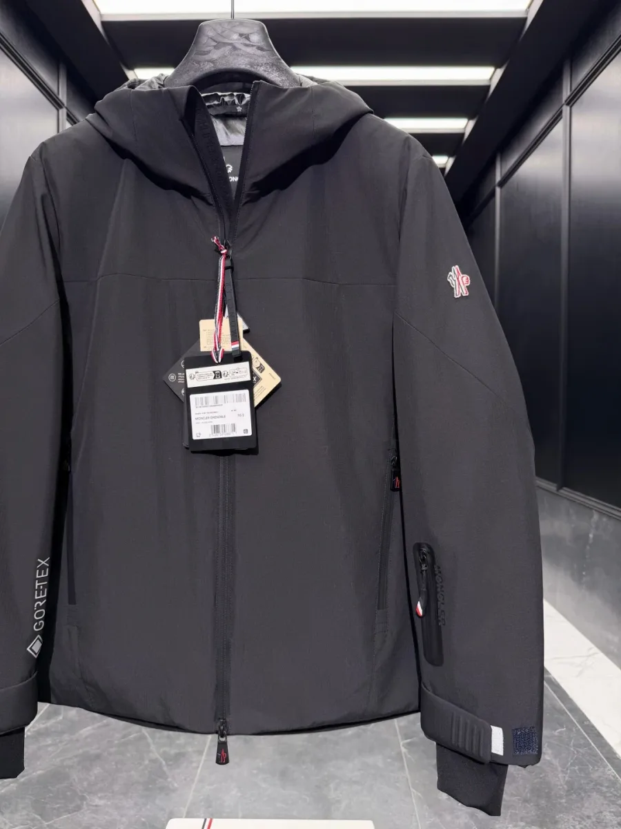 Верхняя часть чёрного пуховика Moncler Grenoble с прорезиненной центральной молнией и капюшоном