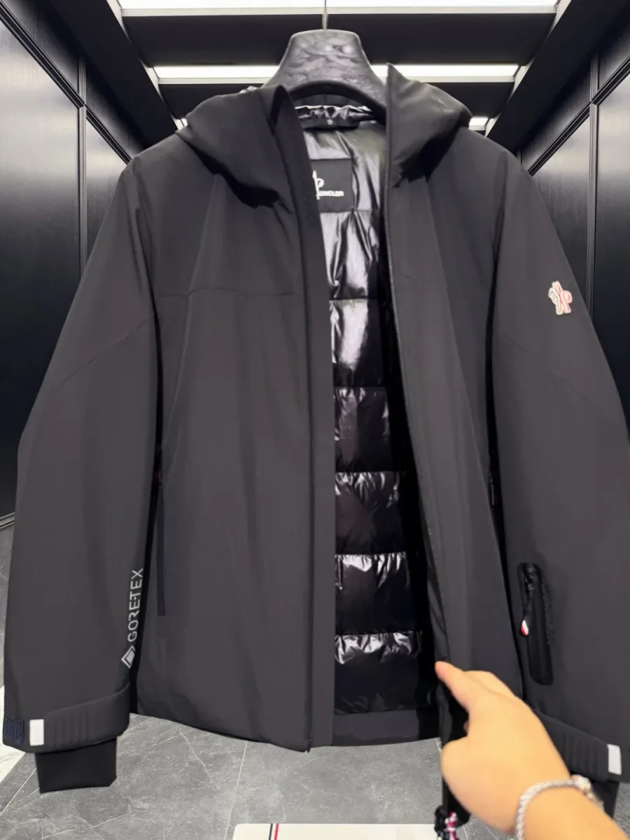 Расстёгнутый чёрный пуховик Moncler Grenoble с глянцевой стёганой пуховой подкладкой внутри