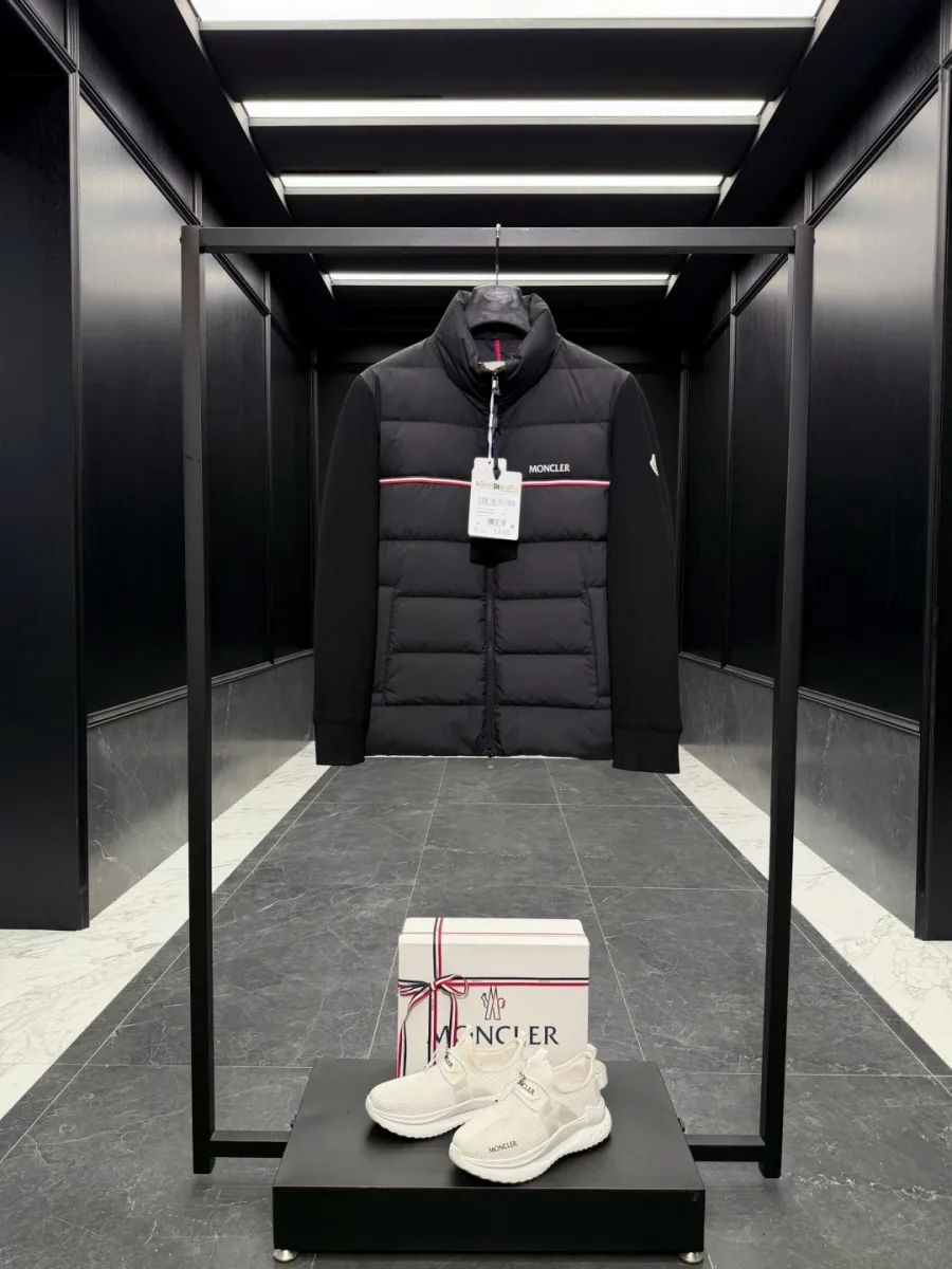 Чёрный пуховый кардиган Moncler на вешалке, общий вид спереди с контрастной полосой на груди