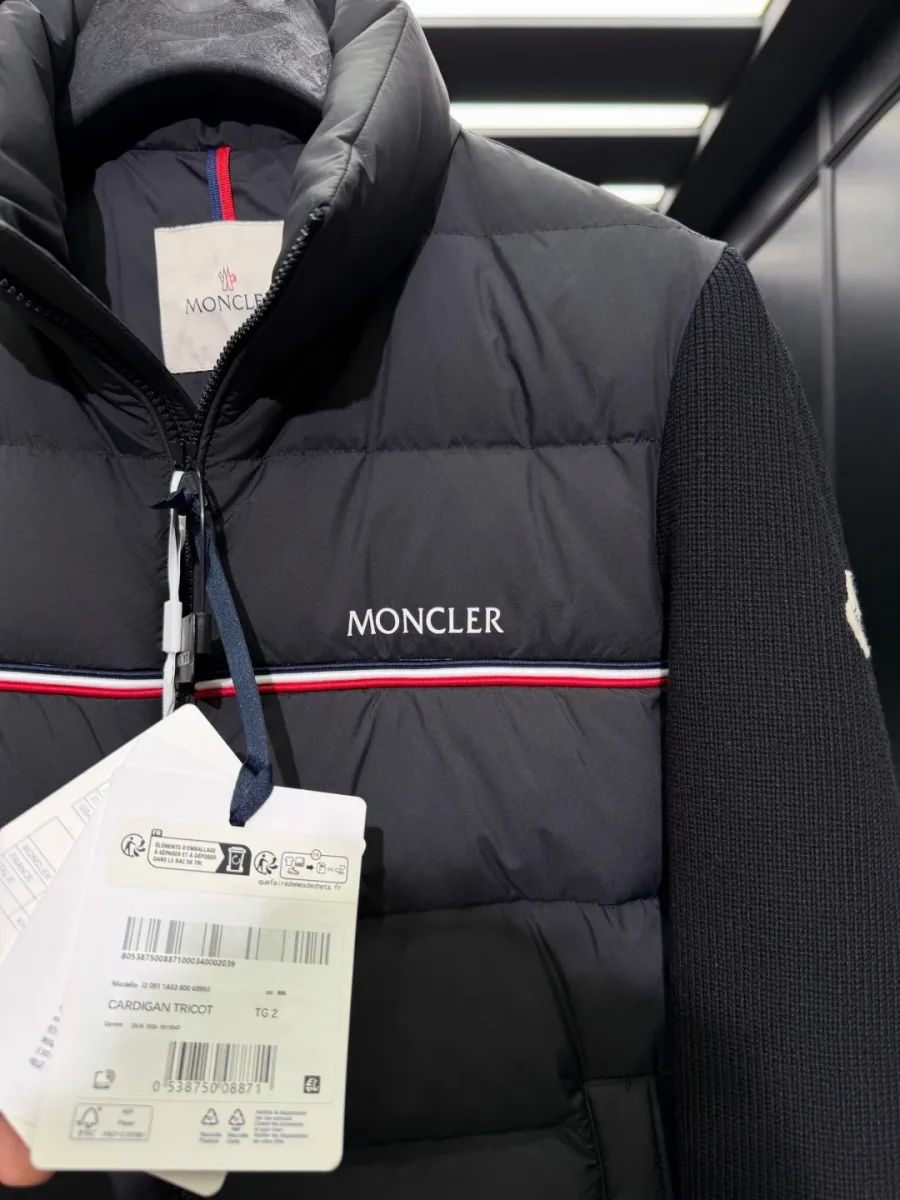 Крупный план воротника-стойки, молнии и полосы с надписью Moncler на груди кардигана