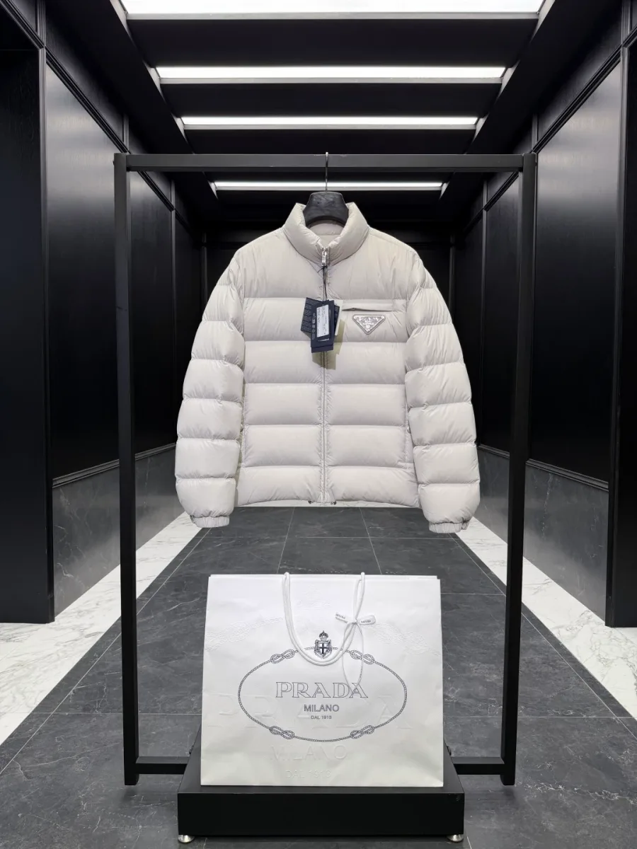Светло-бежевый стёганый пуховик Prada с воротником-стойкой на рейле, вид спереди