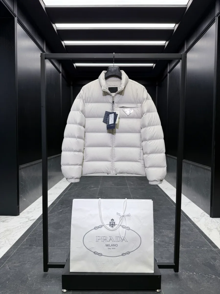 Светло-бежевый пуховик Prada с горизонтальной стёжкой и нагрудным карманом, фронтальный ракурс