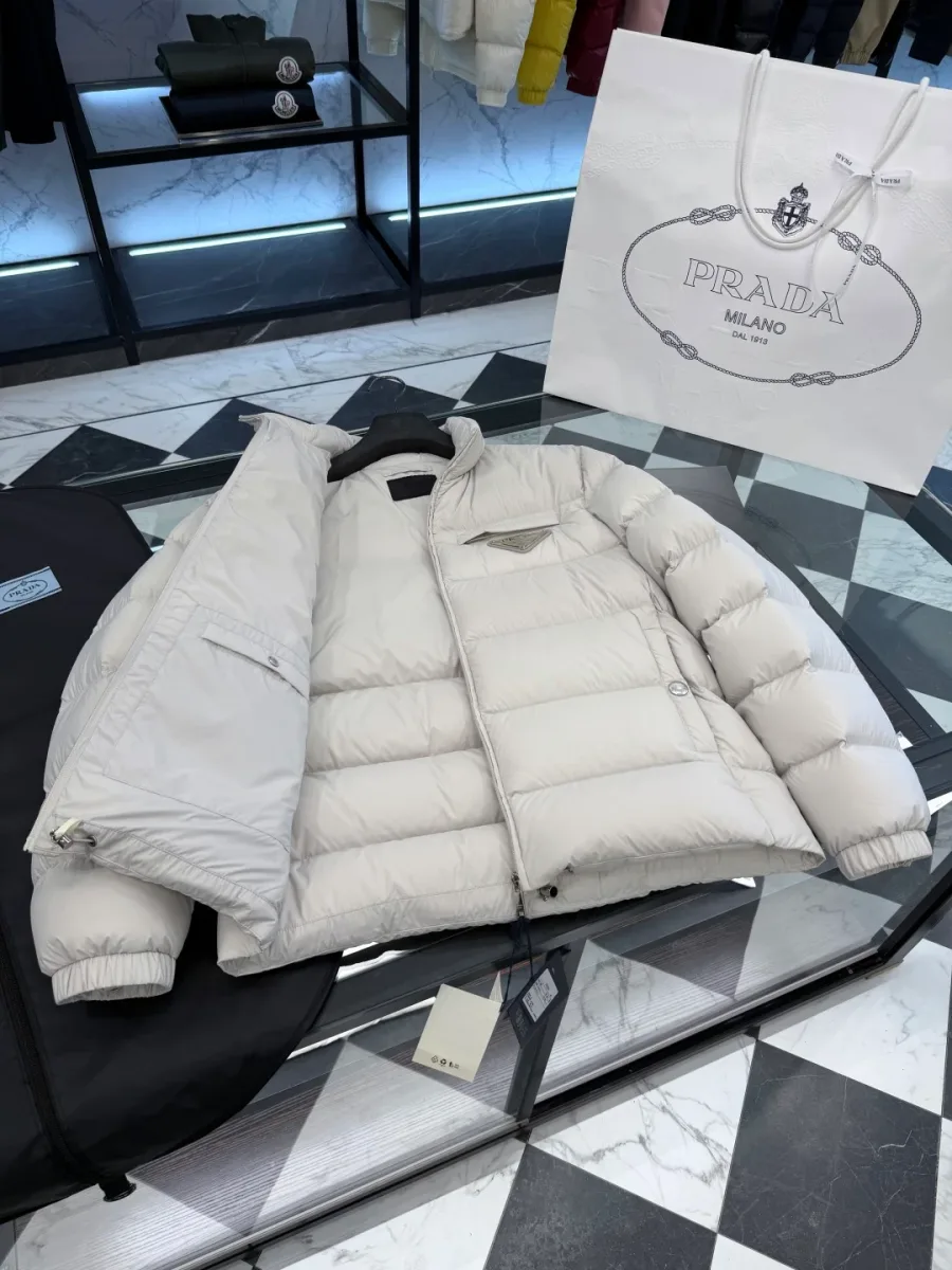 Внутренняя сторона правой полочки светло-бежевого пуховика Prada с прорезным карманом на молнии