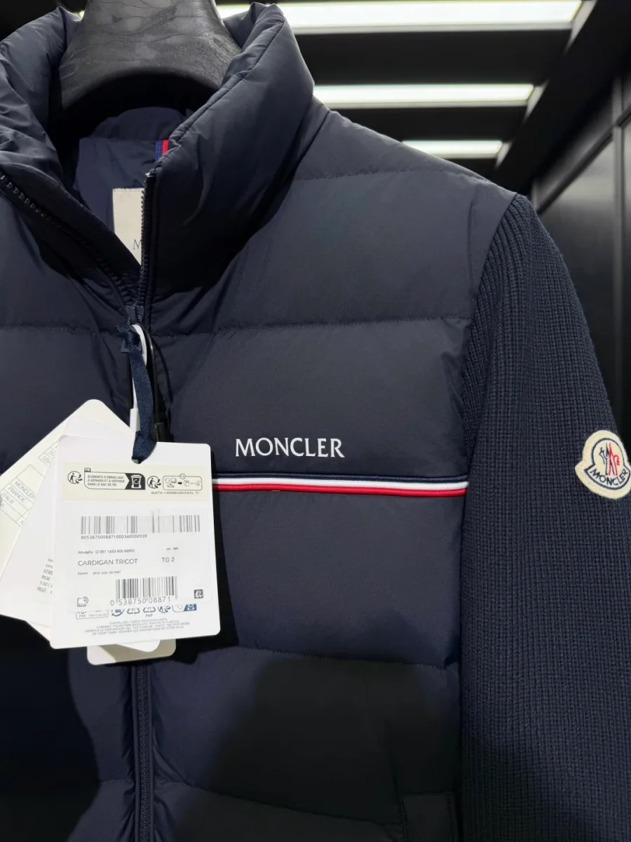 Воротник-стойка, молния и контрастная полоса с логотипом Moncler на груди крупным планом