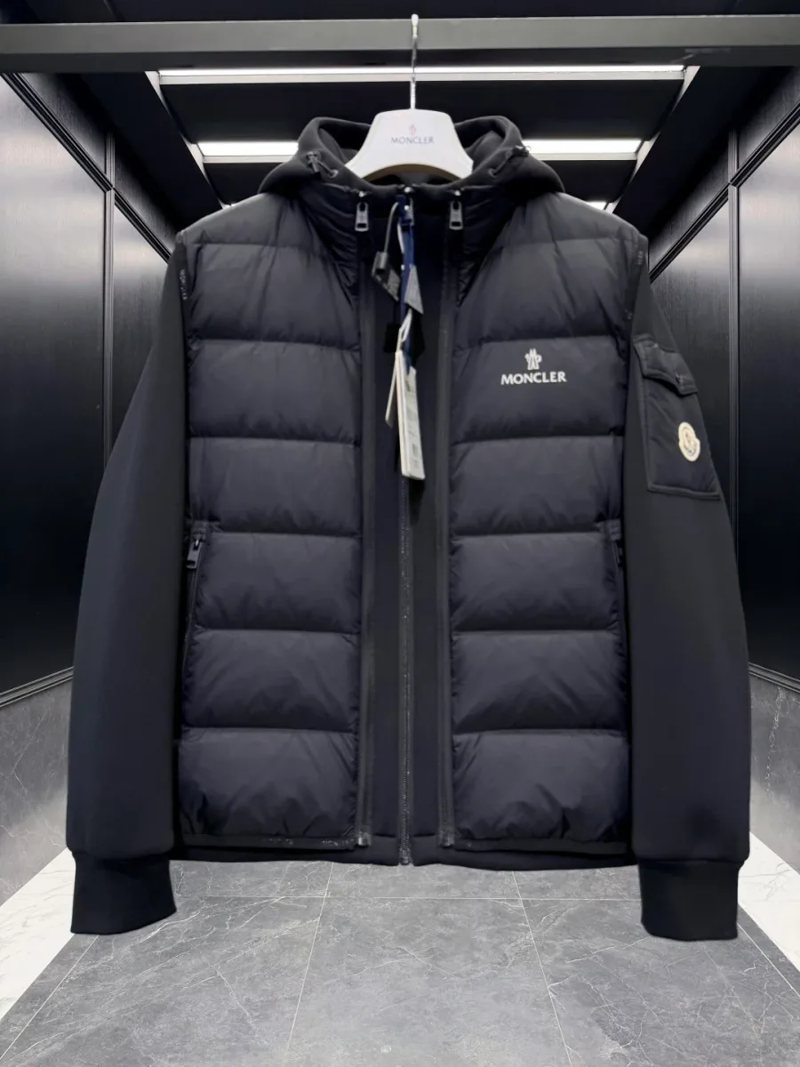 Чёрная куртка с надетым пуховым жилетом Moncler на вешалке, крупный план спереди