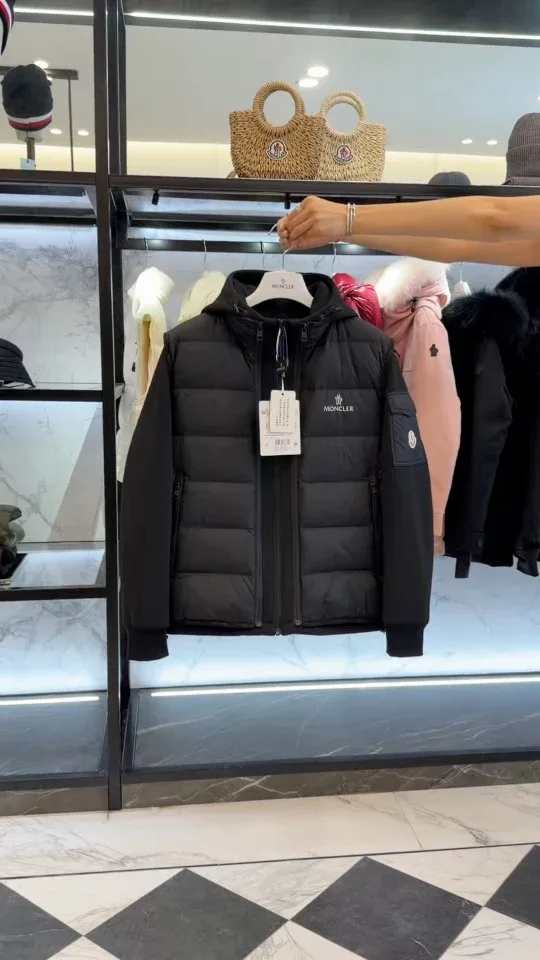 Чёрный комплект Moncler на вешалке в торговом зале, общий план спереди