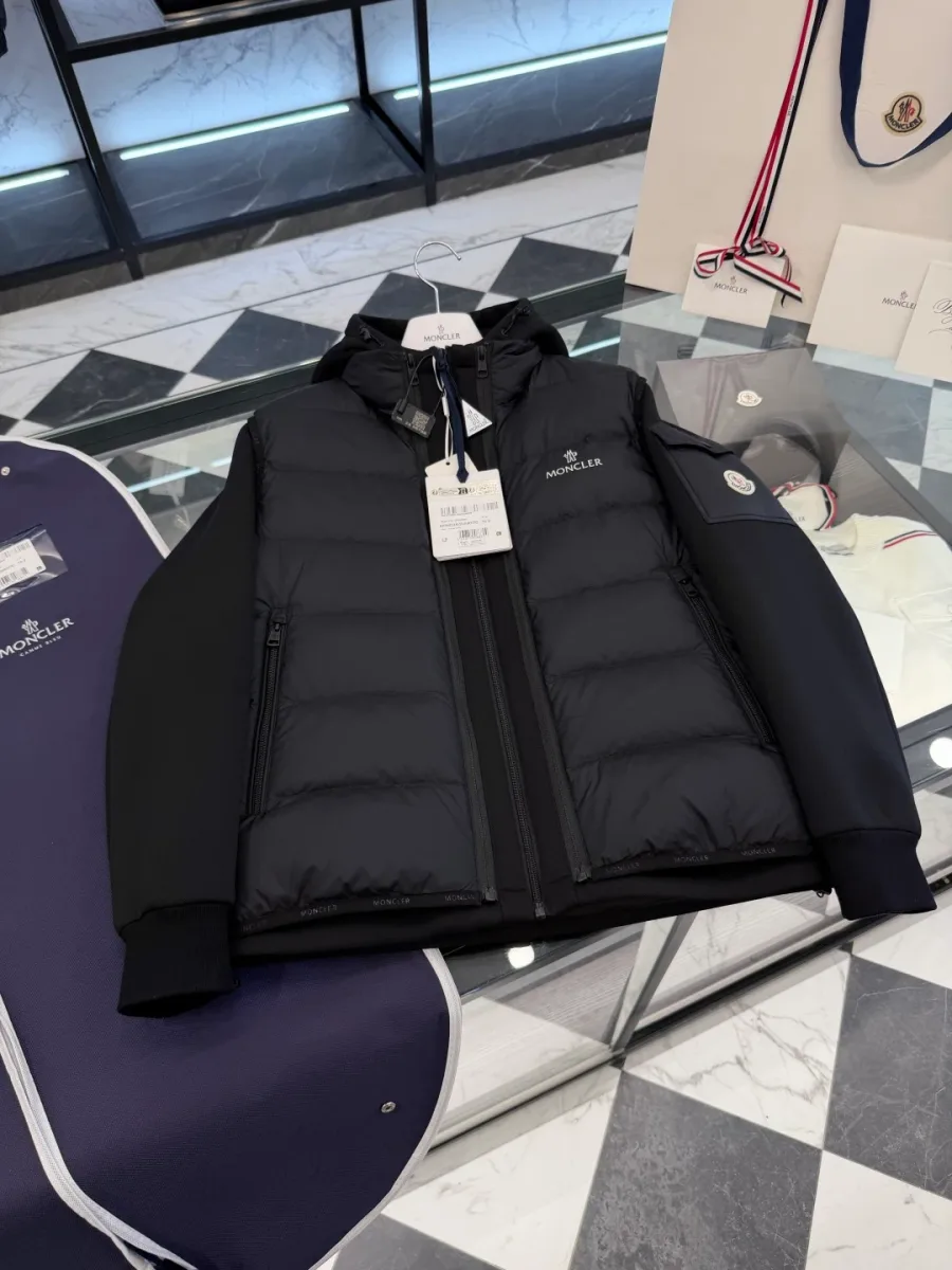 Комплект Moncler из чёрной куртки и пухового жилета на столе, вид спереди