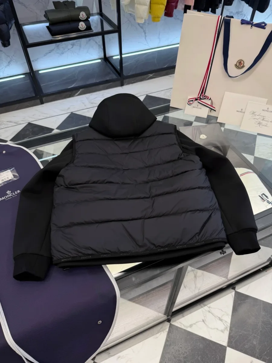 Комплект из чёрной куртки и пухового жилета Moncler, вид со спины на столе