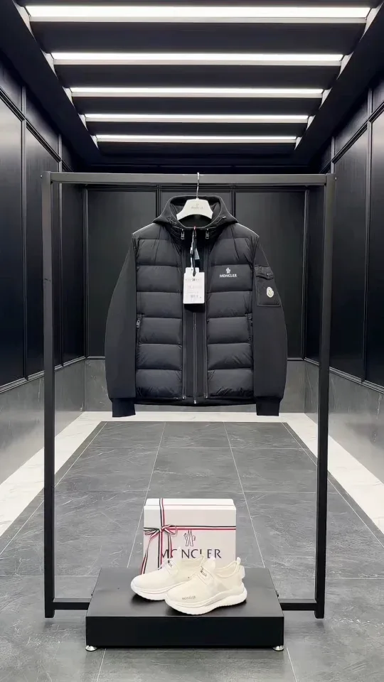 Чёрный комплект Moncler на стойке в интерьере шоурума, фронтальный вид
