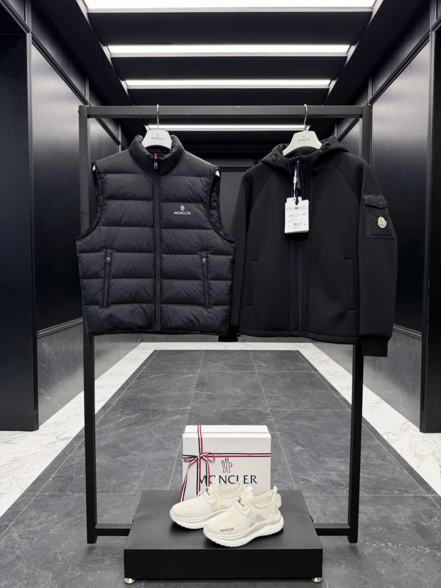 Комплект из пухового жилета и куртки Moncler на двух вешалках рядом, вид спереди