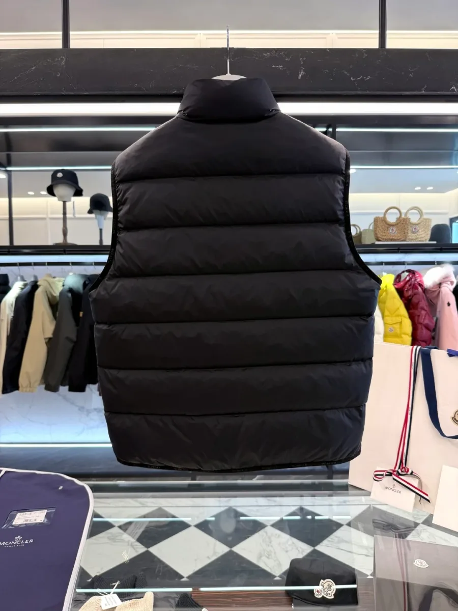 Чёрный пуховый жилет Moncler с воротником-стойкой на вешалке, вид со спины