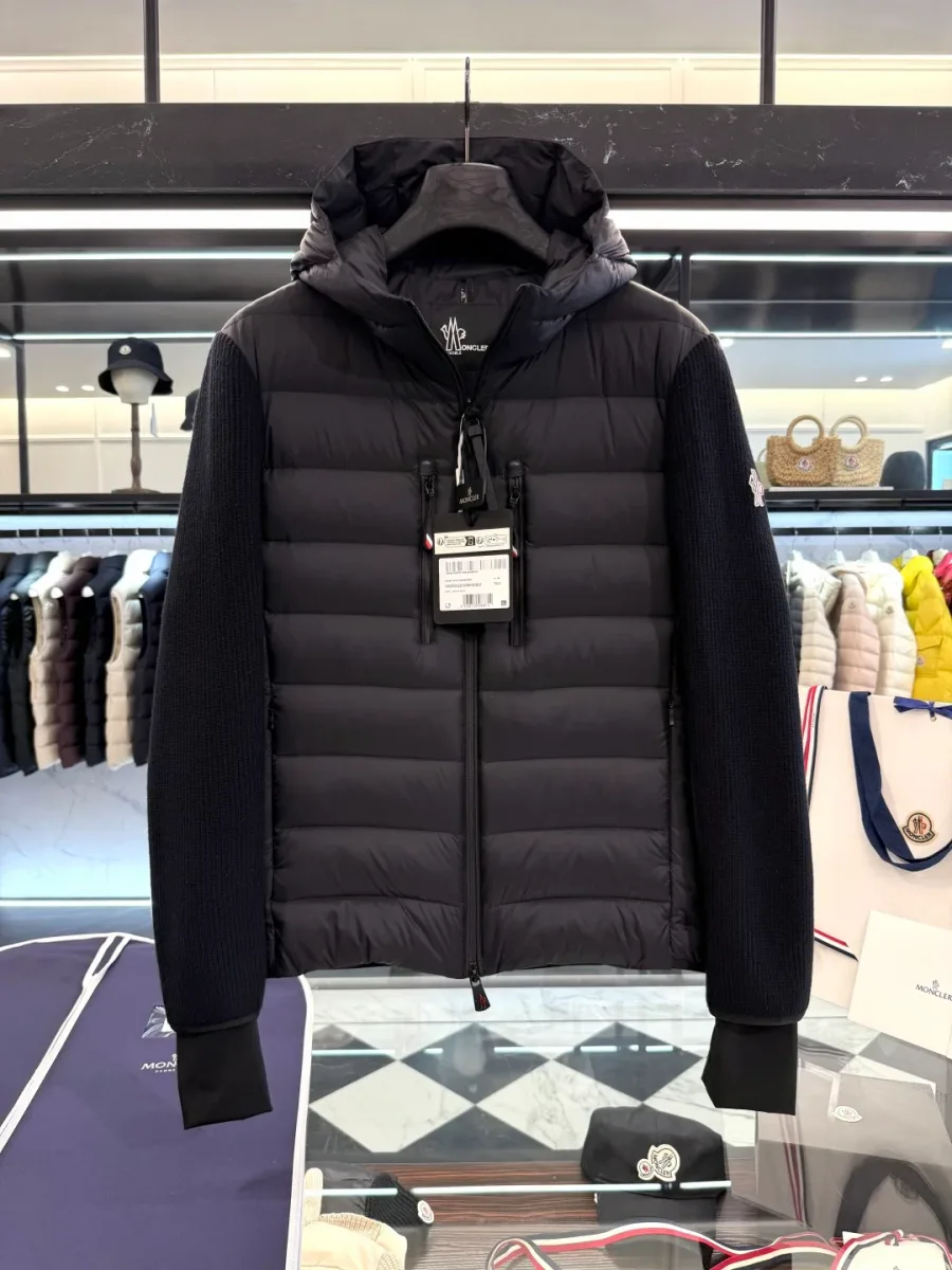 Чёрная куртка Moncler с трикотажными рукавами и капюшоном на вешалке, фронтальный вид