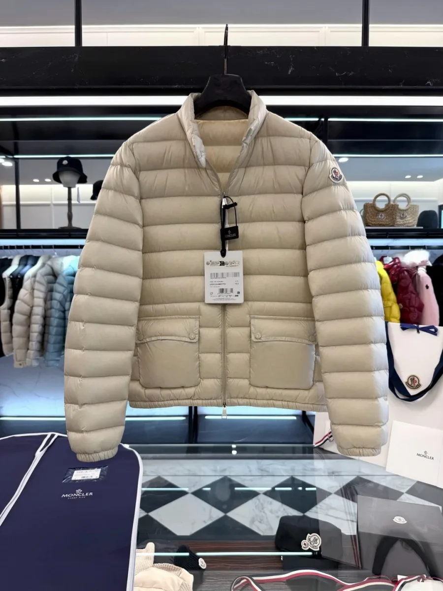 Светло-бежевый стеганый пуховик Moncler Lans на вешалке в магазине