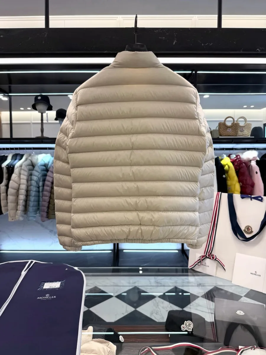 Бежевый пуховик Moncler Lans, вид со спины на вешалке в интерьере