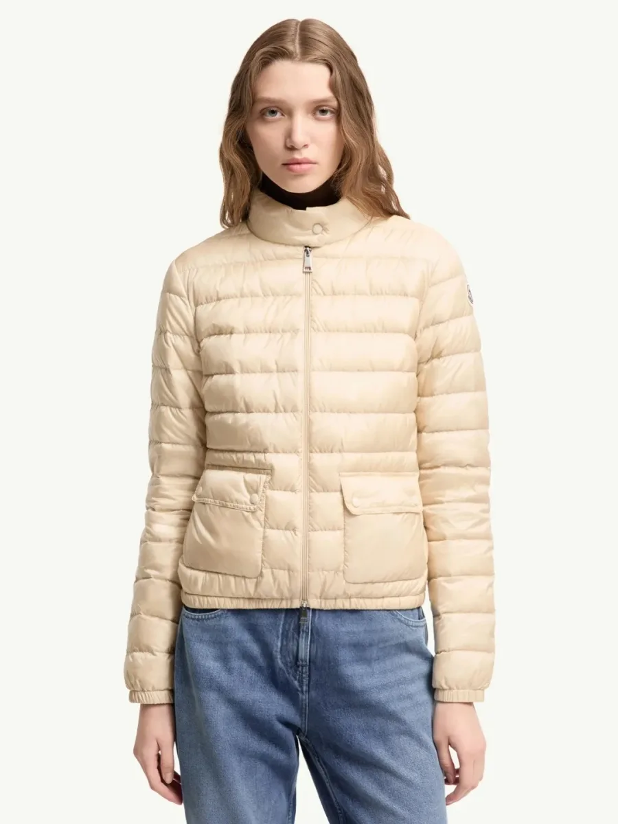 Модель в бежевом пуховике Moncler Lans и джинсах, вид спереди