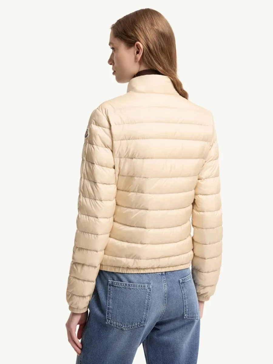 Модель в бежевом стеганом пуховике Moncler Lans, вид со спины в три четверти
