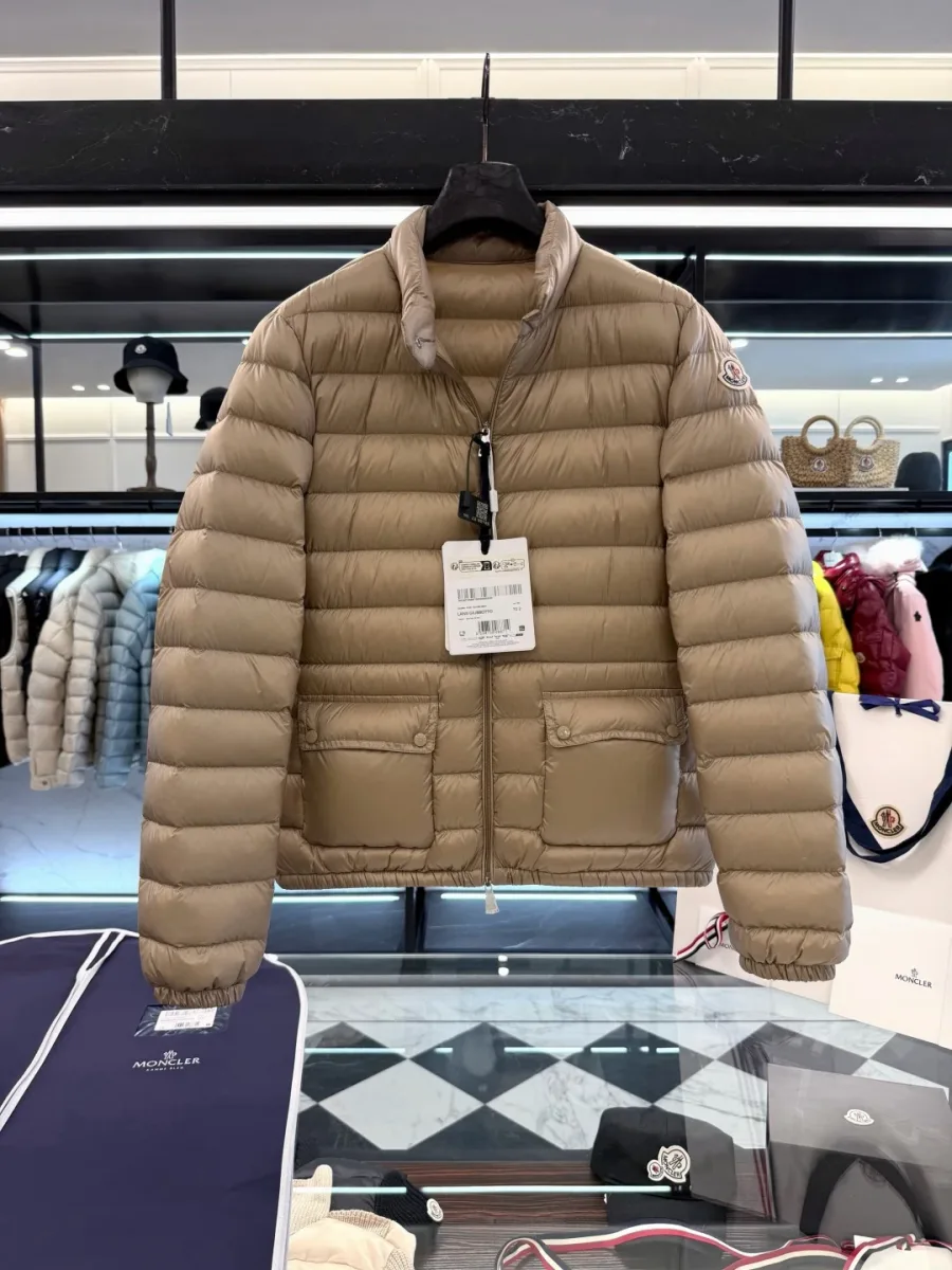 Бежевый пуховик Moncler Lans с расстегнутым воротом на вешалке