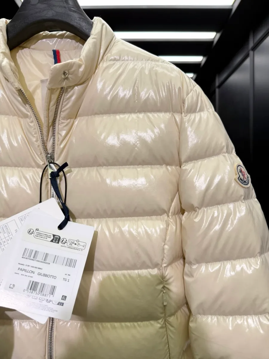 Воротник-стойка пуховика и молния с фирменными бирками, крупный план деталей