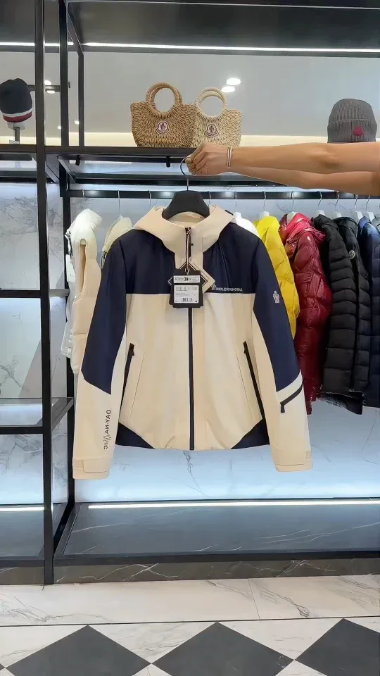 Куртка Moncler Grenoble на вешалке на фоне рейла с одеждой