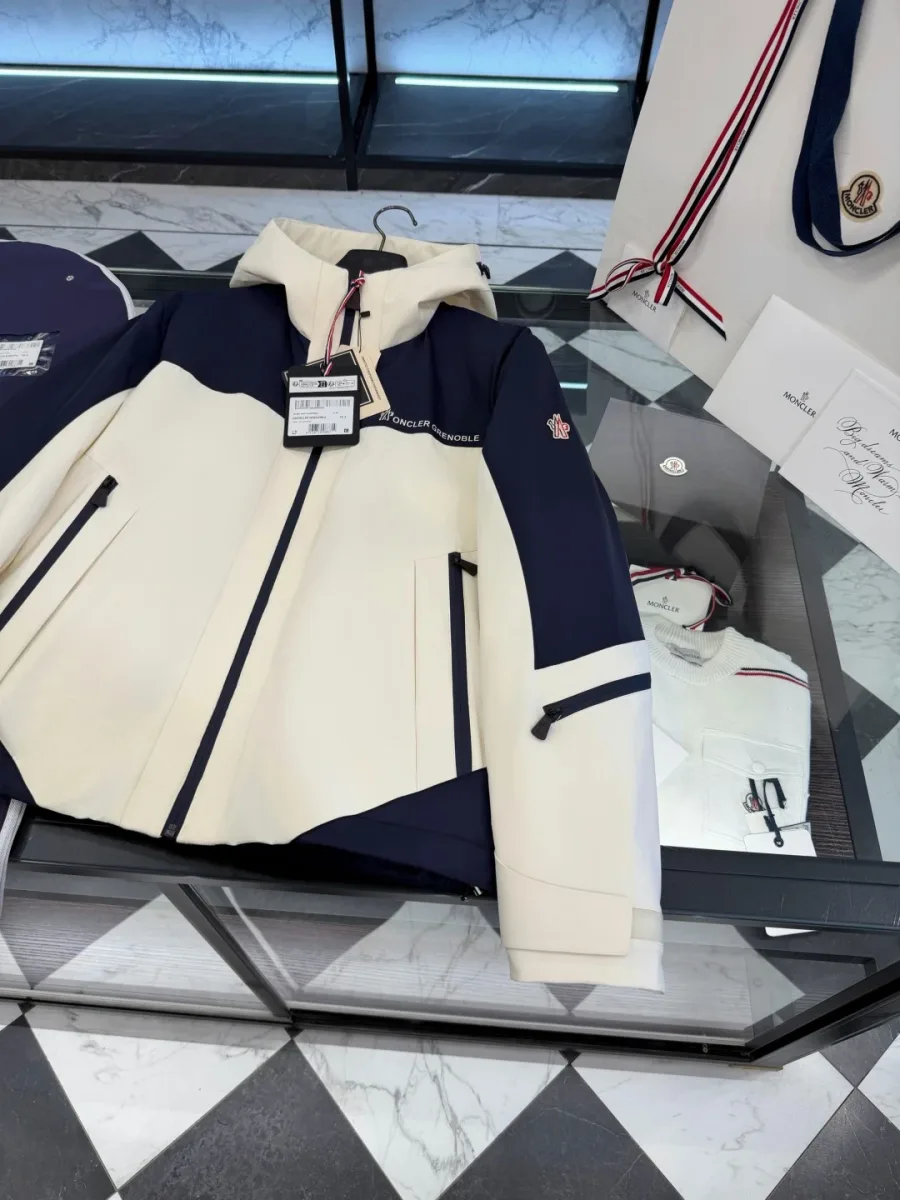 Разложенная куртка Moncler Grenoble на стеклянном столе, вид спереди под углом
